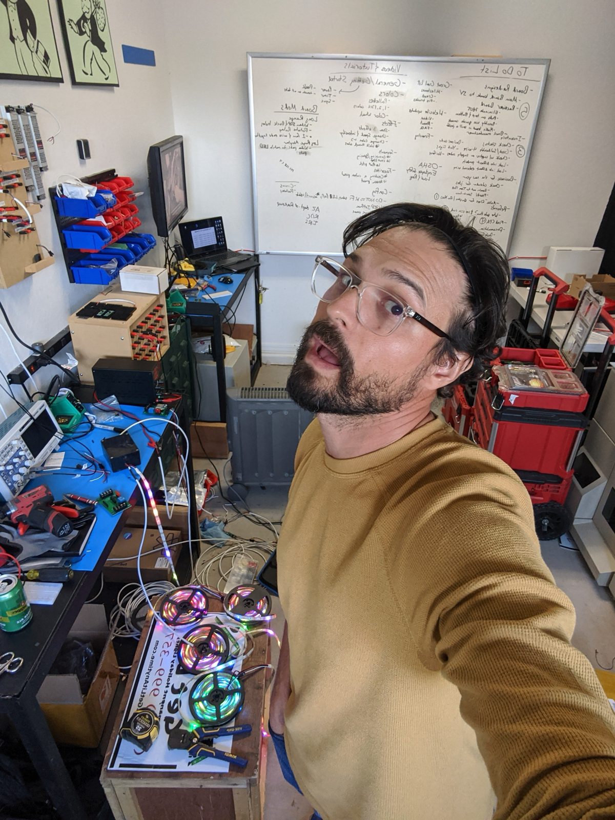 Steven in the workshop beside reels of lit LED strips